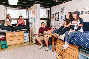 Student with guitar and other students