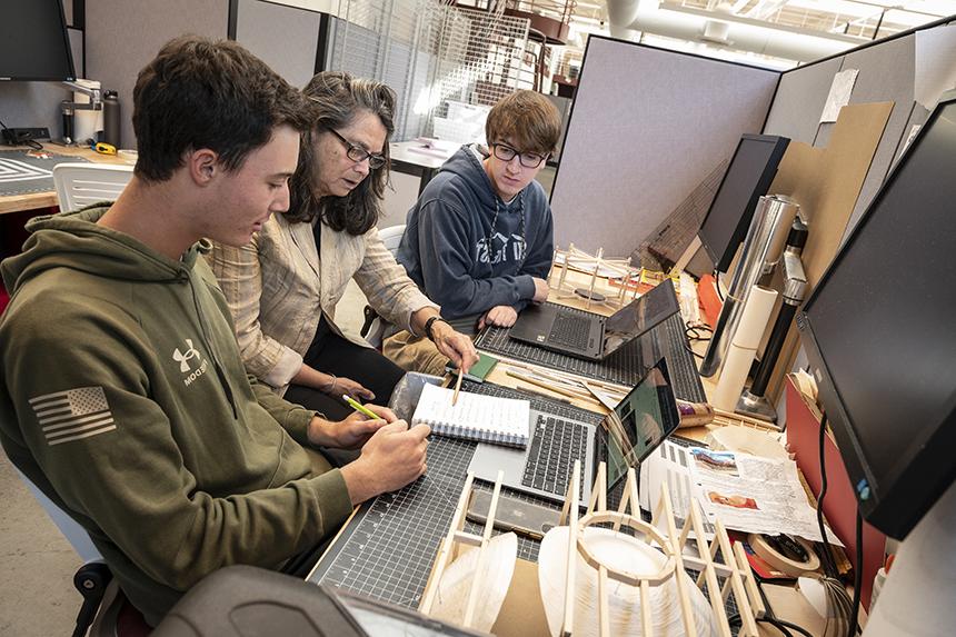 Two students and a professor working in the Arch building 