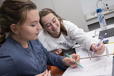 Two students sit together working